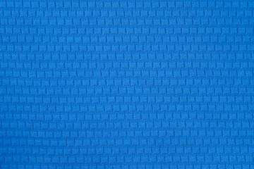 Blue polyester fabric background. A fragment of a t-shirt for sports. Close-up polyester, synthetic fabric for sewing clothes.