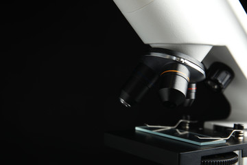 Closeup view of modern microscope on black background, space for text. Medical equipment