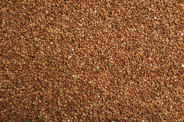 Uncooked buckwheat grains as background, top view