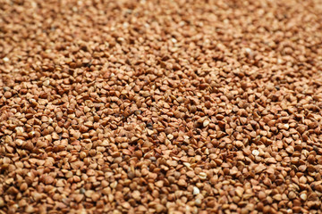 Uncooked organic buckwheat grains as background, closeup