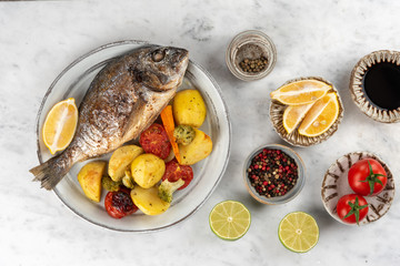 Baked dorado (dorada) fish on a plate, top view