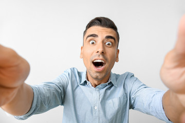 Surprised young man on light background