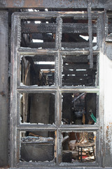 Charred window of a burnt house
