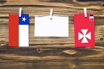 Hanging flags of Chile and Wallis And Futuna attached to rope with clothes pins with copy space on...