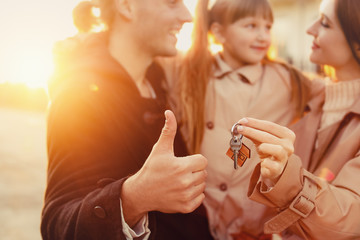 Young family with key near their new house