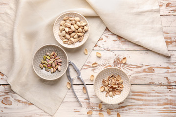 Obraz na płótnie Canvas Tasty pistachio nuts with nutcracker on table