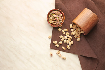 Fototapeta na wymiar Tasty pistachio nuts on light background