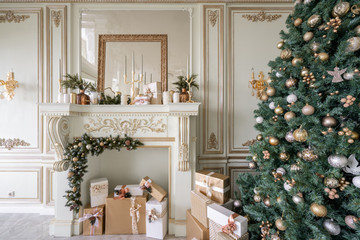 Christmas morning. Classic luxurious apartments with decorated christmas tree and presents. Living with fireplace, columns and stucco.