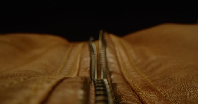 Close up of zipping up a leather jacket, macro shot of zipper on brown leather bag, everyday task, dramatic look, red epic