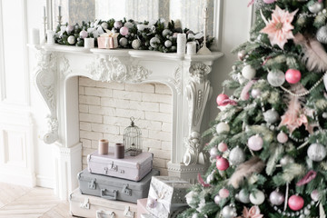 Christmas morning. Classic luxurious apartments with decorated christmas tree and presents. Living with fireplace, columns and stucco.