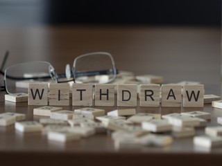 The concept of Withdraw represented by wooden letter tiles