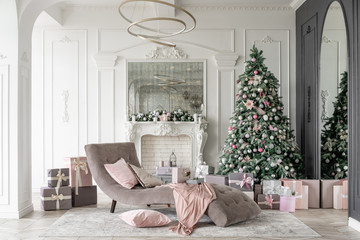 Christmas morning. Classic luxurious apartments with decorated christmas tree and presents. Living with fireplace, columns and stucco.