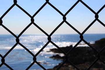 view of the beach through a fence