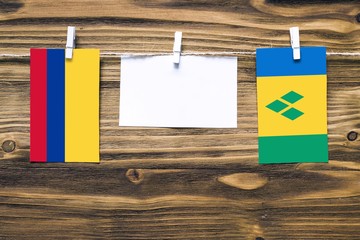 Hanging flags of Colombia and Saint Vincent And The Grenadines attached to rope with clothes pins...