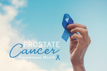 Man Hands holding blue ribbon over blue sky, Prostate Cancer Awareness, November blue, Men health...