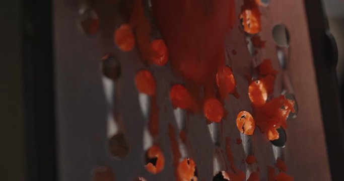Chef grinding carrot on grater close up, macro shot of cooking process, red epic, dramatic look, slow motion