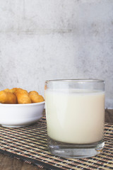 Soy milk in a glass and cup of fried cassava flour Resting on a brown wooden table