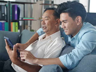 Lifestyles​ man father​ and son​ working on laptop in office