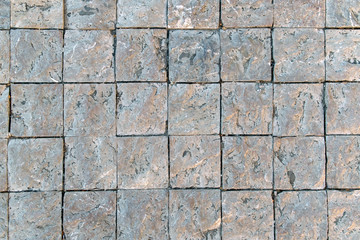 Fototapeta premium Granite cobblestoned pavement background. Fragment of a pavement along a street in Greece.