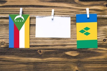 Hanging flags of Comoros and Saint Vincent And The Grenadines attached to rope with clothes pins...