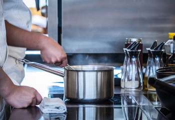 Traditional preparing food and professional Chinese cooks at kitchen.