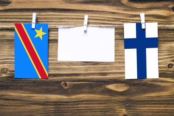 Hanging flags of Congo and Finland attached to rope with clothes pins with copy space on white note...