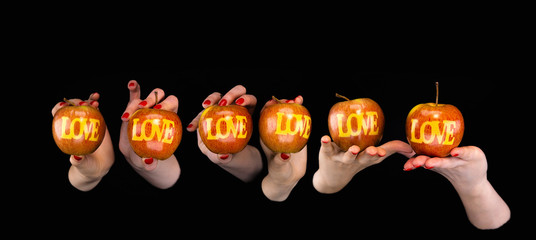 Women hands hold apples with the LOVE inscription