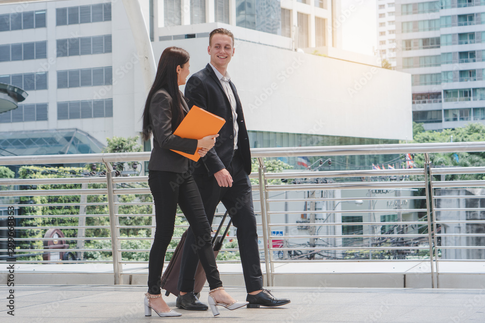 Wall mural businessman and businesswoman talking and hold luggage travel to business trip.