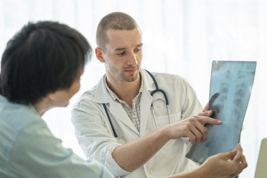 Doctor explaining result of radiography test to patient.