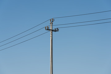 A power pole in a cloudless blue sky closeup