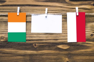 Hanging flags of Cote D'Ivoire and Indonesia attached to rope with clothes pins with copy space on...