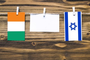 Hanging flags of Cote D'Ivoire and Israel attached to rope with clothes pins with copy space on...