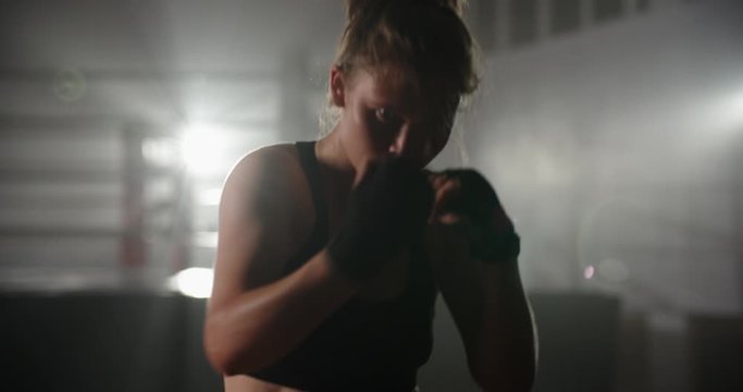 Caucasian sportswoman training in a gym, doing a shadow fight, preparing for kickboxing tournament - fitness, sports concept 4k footage