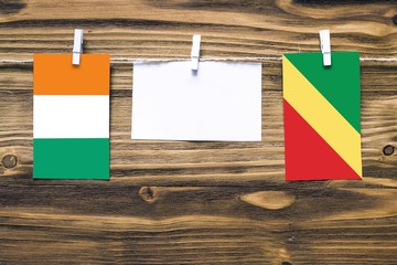 Hanging flags of Cote D'Ivoire and Republic Of The Congo attached to rope with clothes pins with...
