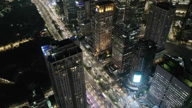 Futuristic skyscraper Jakarta cityscape aerial view high above night illuminated business towers capital city traffic below. Sudirman. Senayan