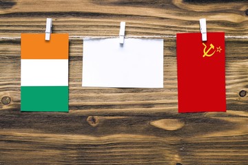 Hanging flags of Cote D'Ivoire and Soviet Union attached to rope with clothes pins with copy space...