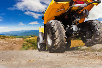 Atv vehicle standing on a mountain landscape road. © breakermaximus