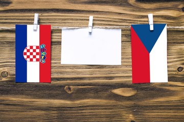 Hanging flags of Croatia and Czech Republic attached to rope with clothes pins with copy space on...
