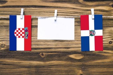 Hanging flags of Croatia and Dominican Republic attached to rope with clothes pins with copy space...