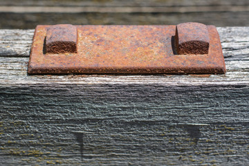 Rusted bolts and plate, worn weathered steel.