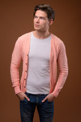 Studio shot of young handsome man against brown background