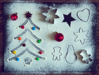 Christmas gingerbread cookies and fir tree and christmas decorations on dark stone background. Top view