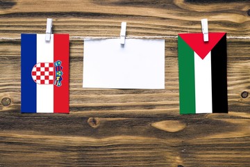 Hanging flags of Croatia and Palestine attached to rope with clothes pins with copy space on white...