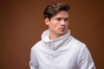 Obraz premium Studio shot of young handsome man against brown background
