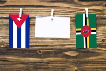 Hanging flags of Cuba and Dominica attached to rope with clothes pins with copy space on white note...