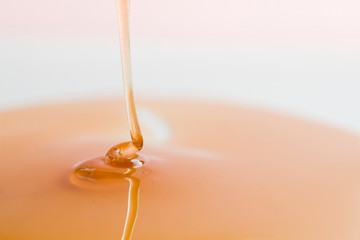 Thick, viscous honey of saturated color flows down.