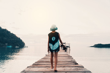A girl walking on the bridge resting on the sea and holiday to travel concept.