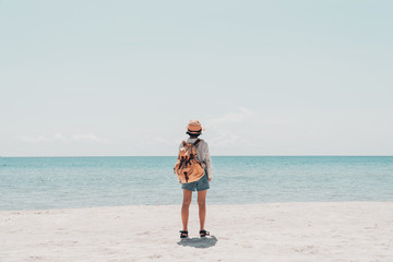 Cute girl backpack and travel on the beach.