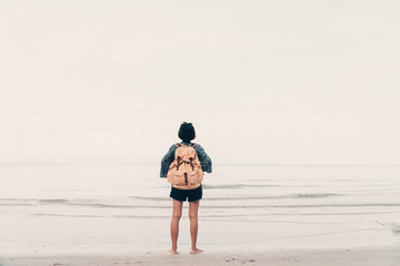 Cute girl backpack and travel on the beach.