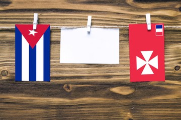 Hanging flags of Cuba and Wallis And Futuna attached to rope with clothes pins with copy space on...